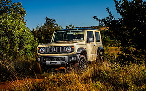 Suzuki Jimny Off-Road SUV in Golden Grassland Under Clear Blue Sky HD wallpaper