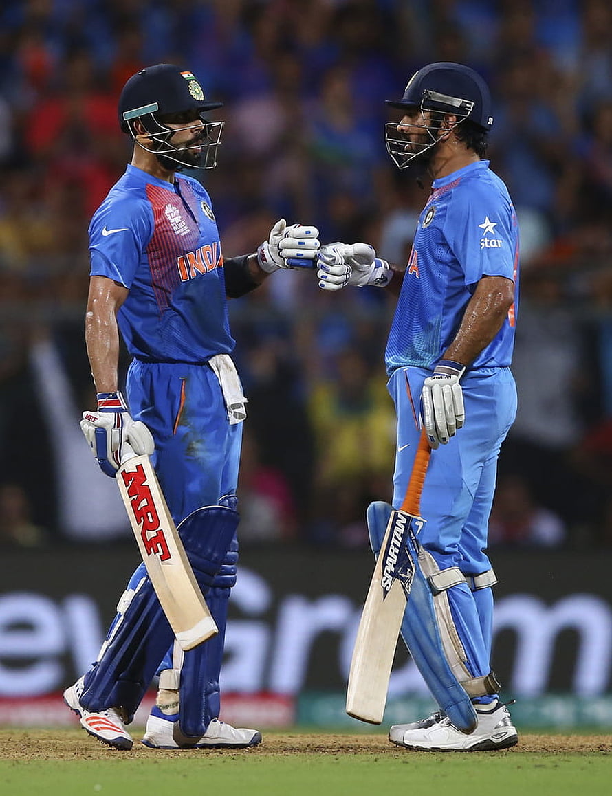 Indian cricket players Virat Kohli and Rohit Sharma celebrate together on the field wearing blue jerseys HD phone wallpaper