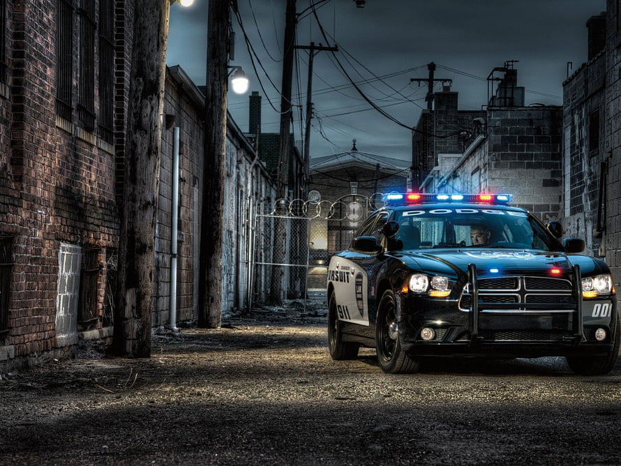 Black Dodge Charger Police Cruiser with Active Lights in a Dark Urban Alley HD wallpaper