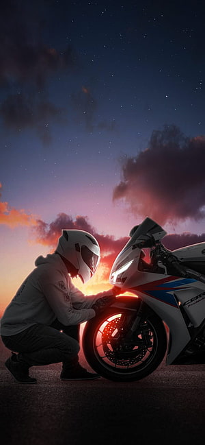 Biker Crouching Beside Sport Motorcycle at Sunset with Starry Sky HD phone wallpaper