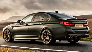 Matte Green BMW M5 Competition with Bronze Wheels on a Scenic Road HD wallpaper