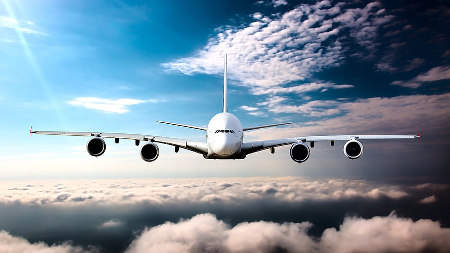 Large Commercial Jetliner Cruising Above a Thick Cloud Layer in a Bright Blue Sky HD wallpaper