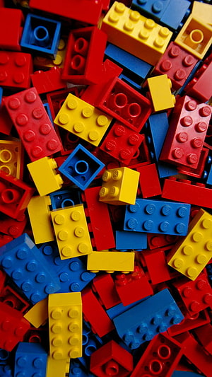 Vibrant pile of red, blue, and yellow LEGO bricks scattered in a colorful close-up HD phone wallpaper