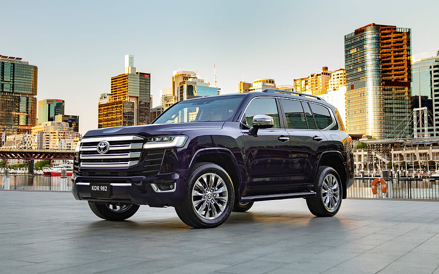 2021 Toyota Land Cruiser 300 Sahara ZX in Deep Purple Parked Against Urban Skyline HD wallpaper