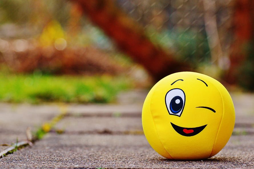 Cheerful Yellow Smiley Ball with Winking Face on Outdoor Path HD wallpaper