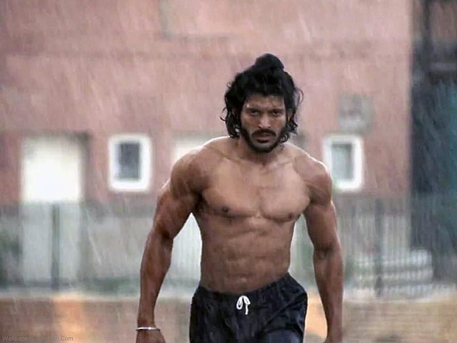 Milkha Singh Running Intensely in the Rain with a Focused Expression HD wallpaper