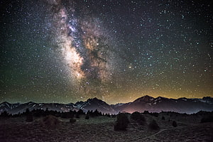 Stunning Milky Way Galaxy Over Snow-Capped Mountain Range at Night HD wallpaper