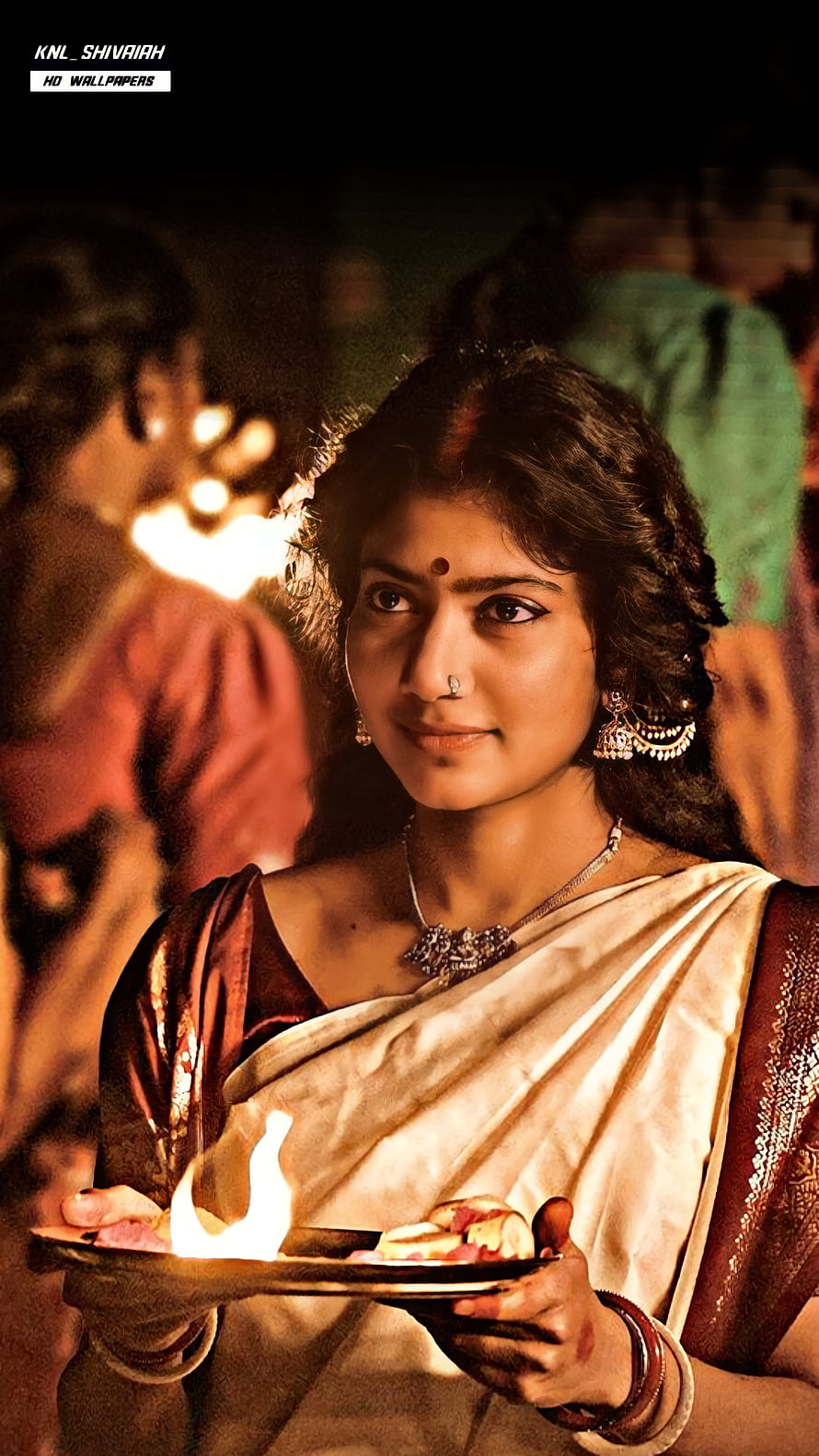 Woman in traditional saree holding a ceremonial lamp during a cultural ritual, Sai pallavi, Sai pallavi HD phone wallpaper