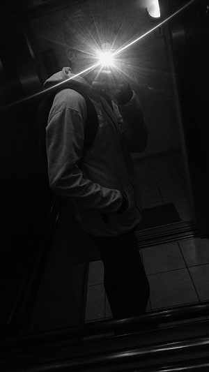 Black and White Mirror Selfie of Person in Hoodie with Bright Flash Lens Flare HD phone wallpaper