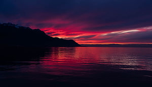 Vibrant Crimson Sunset Over Calm Lake With Mountain Silhouette HD wallpaper