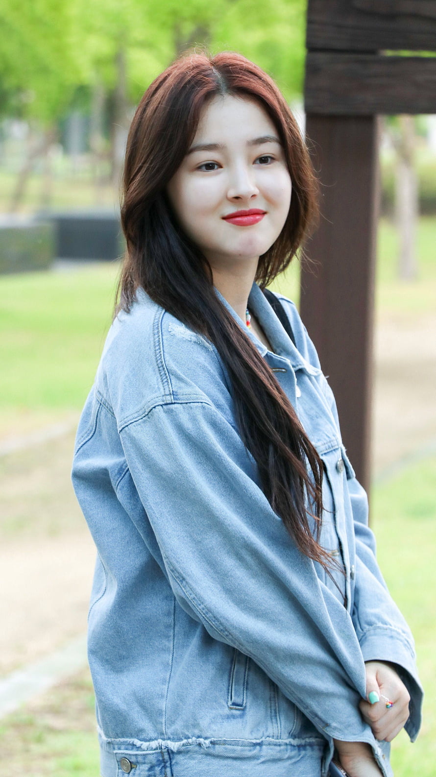 Nancy from Momoland in a casual denim jacket posing outdoors in a park HD phone wallpaper