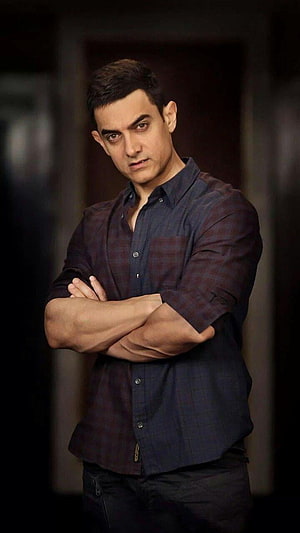Aamir Khan in a dark plaid shirt with arms crossed in a moody portrait HD phone wallpaper