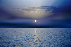 Serene Sunset Over Calm Ocean With Golden Sun Reflection And Blue Sky HD wallpaper