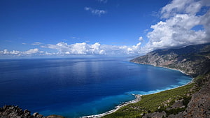 Aerial View of a Pristine Coastal Bay with Turquoise Waters and Rugged Cliffs HD wallpaper