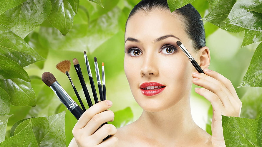 Beautiful Woman Applying Makeup With Brushes Surrounded By Green Leaves, Beauty Salon - Beauty Parlour HD wallpaper