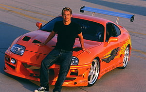 Paul Walker Leaning on Orange Toyota Supra MK4 with Large Rear Wing HD wallpaper