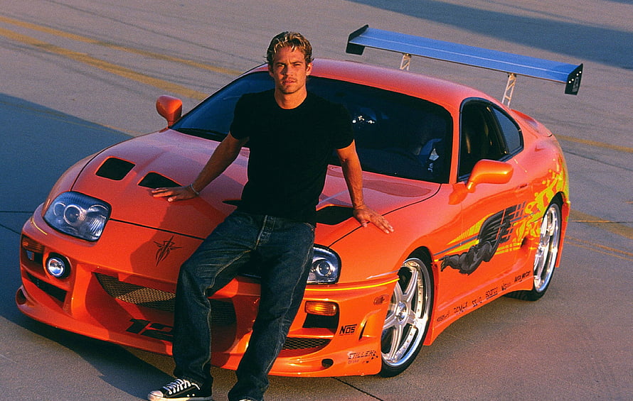 Paul Walker Leaning on Orange Toyota Supra MK4 with Large Rear Wing HD wallpaper