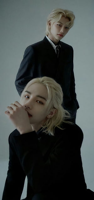 Two blonde men in black suits posing against a grey background HD phone wallpaper