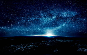 Milky Way Galaxy Arching Over a Dark Rocky Landscape at Night HD wallpaper