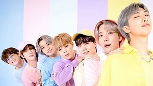 BTS members posing together in colorful pastel outfits against a striped background HD wallpaper
