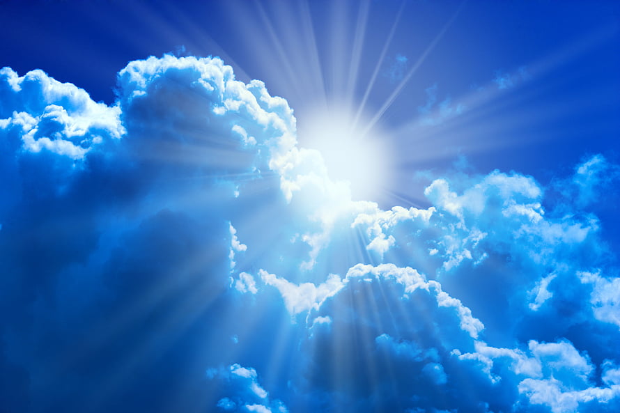 Bright Sun Rays Shining Through Fluffy White Clouds in a Deep Blue Sky HD wallpaper