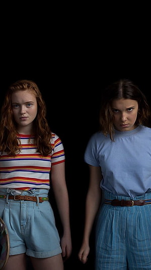 Stranger Things Max and Eleven in 80s Outfits Against Black Background HD phone wallpaper