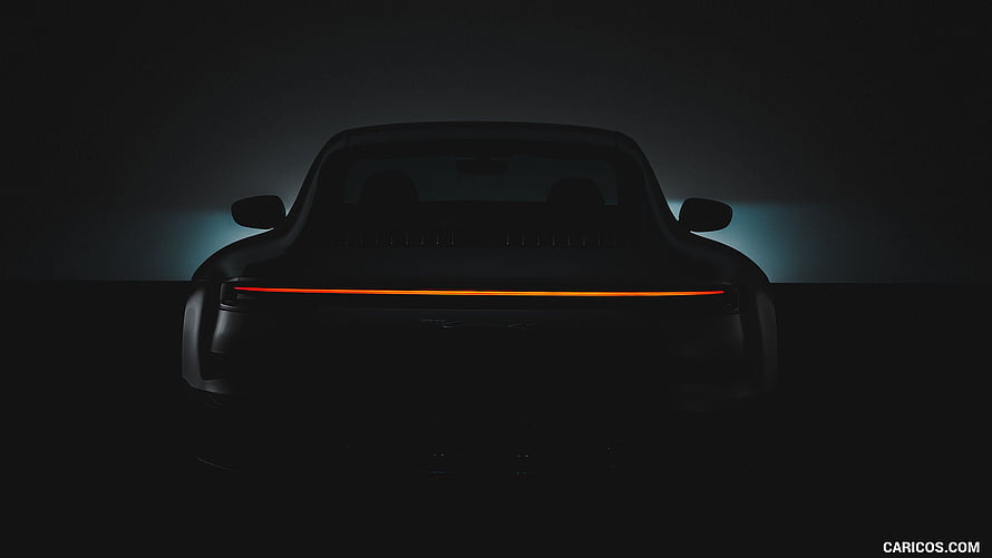 Porsche 911 Carrera 4S Rear View With Glowing Amber Tail Light Strip In Dark Studio Setting HD wallpaper