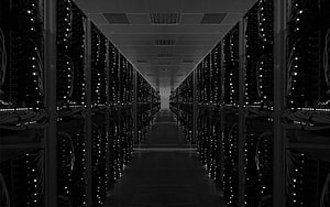 Dark Data Center Aisle with Rows of Server Racks and Glowing Indicator Lights HD wallpaper