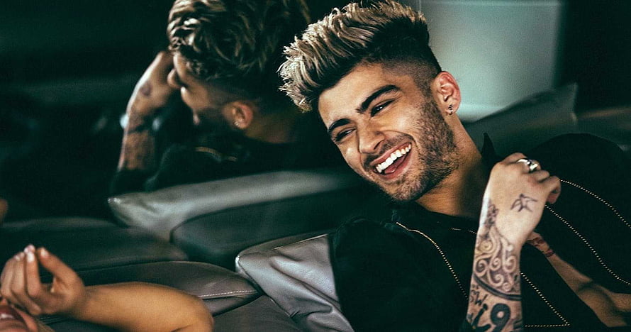 Zayn Malik smiling with tattoos in a dark leather interior HD wallpaper