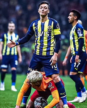 Fenerbahce Player in Blue and Yellow Striped Kit During Intense Soccer Match HD phone wallpaper
