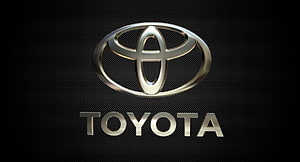 Sleek Metallic Toyota Emblem on Dark Textured Surface HD wallpaper