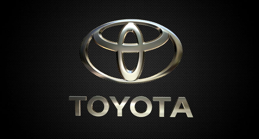 Sleek Metallic Toyota Emblem on Dark Textured Surface HD wallpaper