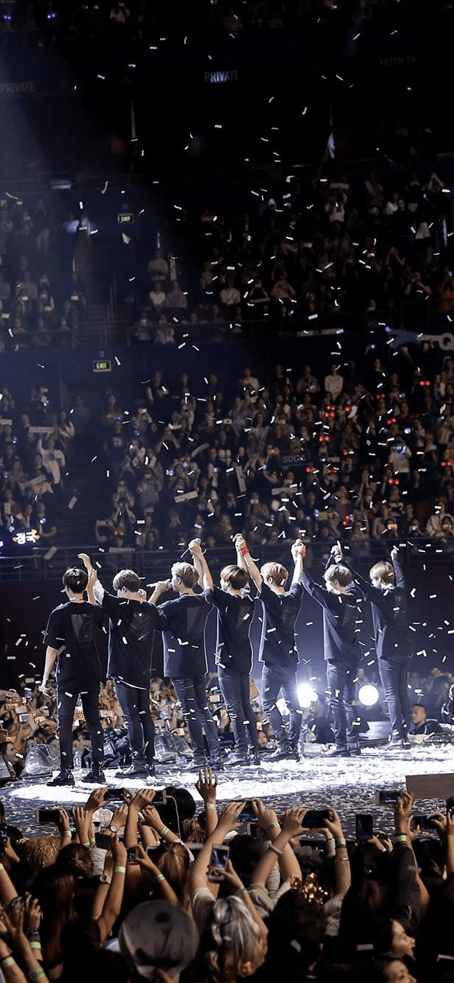 BTS performing on stage with arms raised during a concert with falling confetti and cheering fans HD phone wallpaper