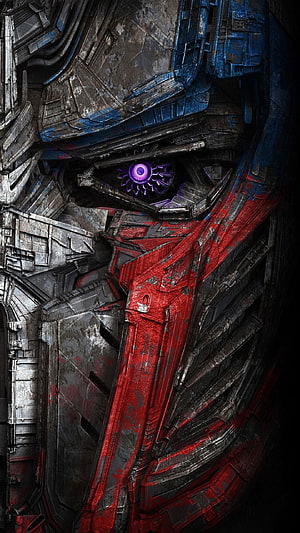 Close-up of Optimus Prime's battle-damaged face with glowing purple eye HD phone wallpaper