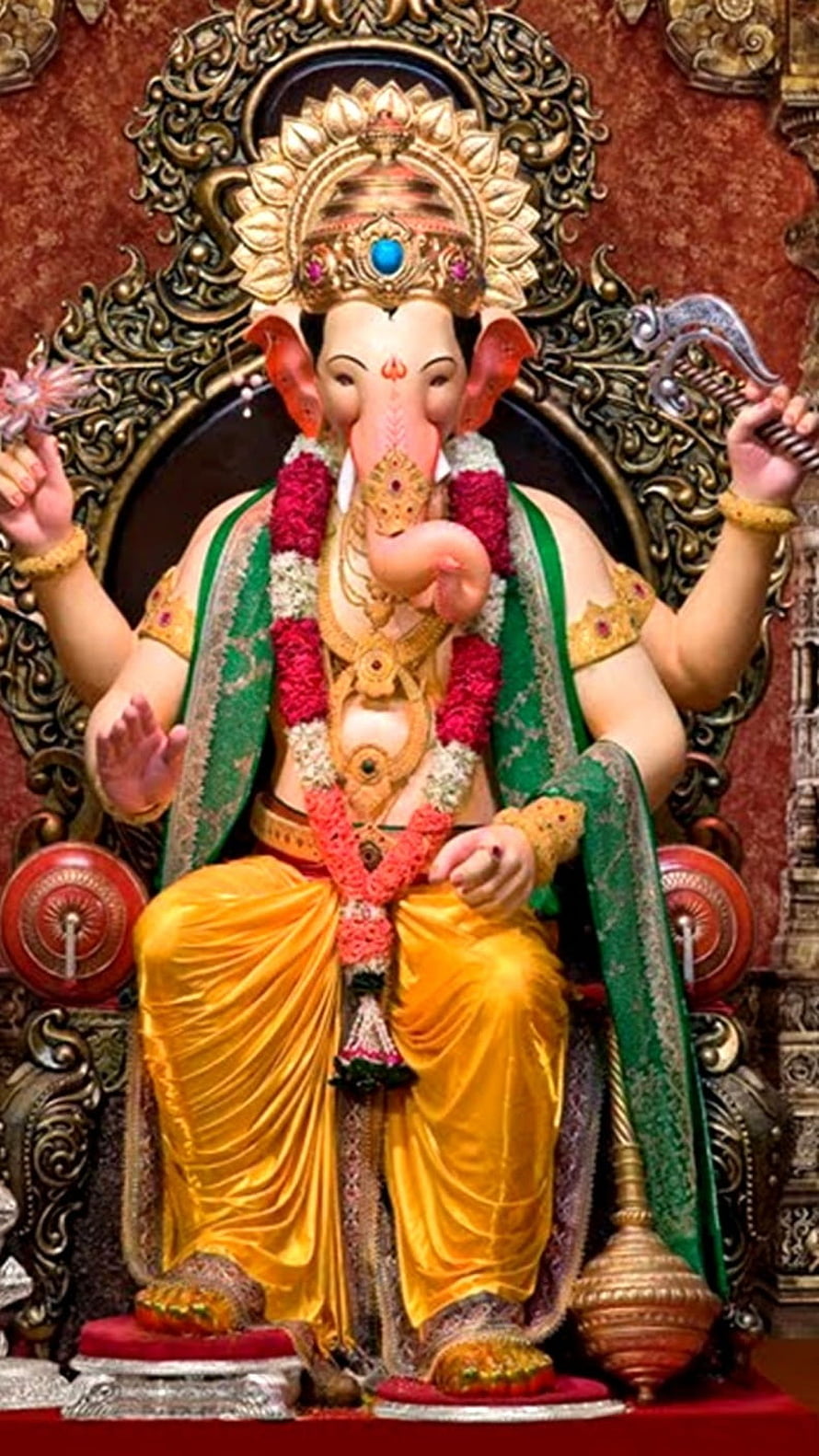 Ornate Ganesha Statue in Yellow and Green Attire with Gold Crown HD phone wallpaper