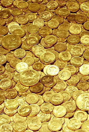 Close-up of scattered gold dollar coins with eagle and profile engravings HD phone wallpaper