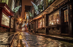 Wet Cobblestone Street in Historic English Town at Night with Festive Lights HD wallpaper