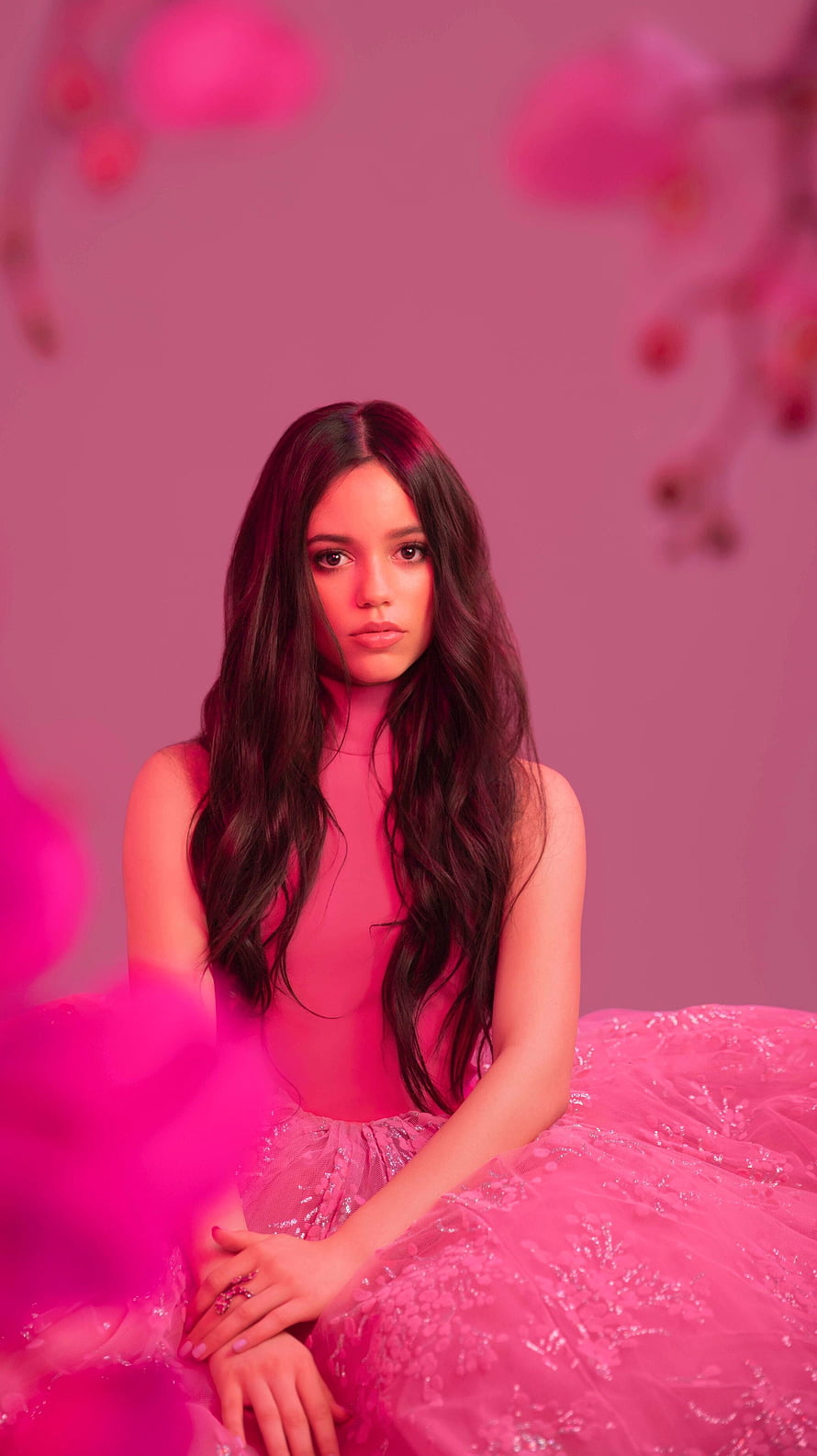 Jenna Ortega in a vibrant pink gown with long dark hair and floral accents HD phone wallpaper