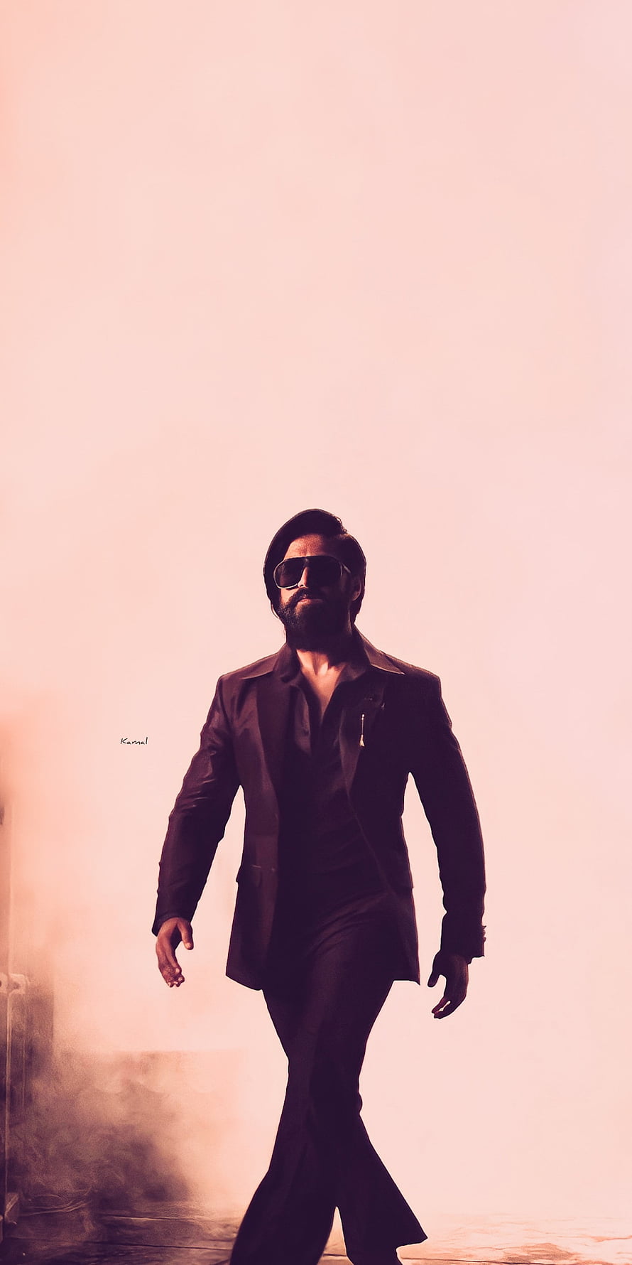 Kamal Haasan in a stylish black suit and sunglasses walking confidently against a pink background HD phone wallpaper