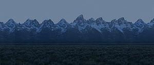 Snow-Capped Mountain Range at Dusk Over a Dark Sagebrush Valley HD wallpaper