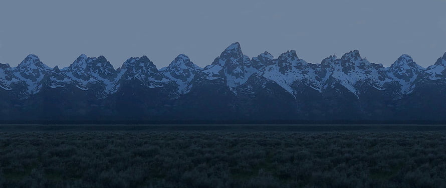 Snow-Capped Mountain Range at Dusk Over a Dark Sagebrush Valley HD wallpaper