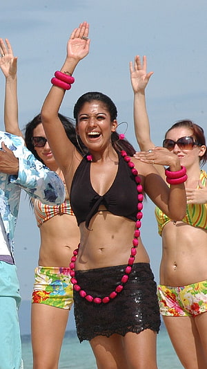 Woman in black bikini top and skirt dancing on beach with pink accessories, Nayantara, villu HD phone wallpaper