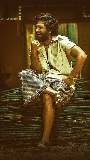 Allu Arjun as Pushpa in a gritty industrial setting wearing a lungi and open shirt HD phone wallpaper