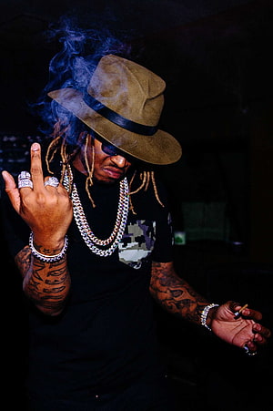 Future Rapper in Fedora and Diamond Chains Smoking Cigar in Dark Studio HD phone wallpaper