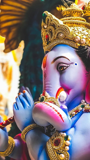 Close-up of Lord Ganesha Statue with Blue Skin, Golden Crown, and Intricate Jewelry HD phone wallpaper