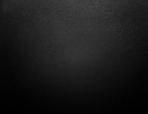 Dark Charcoal Gradient Texture with Subtle Surface Grain and Vignette HD wallpaper