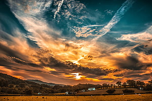 Dramatic Sunset Over Rolling Countryside Hills With Golden Clouds HD wallpaper