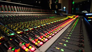 Professional Audio Mixing Console with Glowing Faders and Illuminated Control Knobs in a Recording Studio HD wallpaper