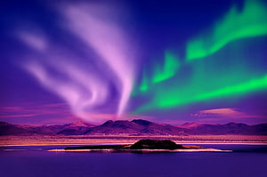 Vivid Aurora Borealis Dancing Over a Mountainous Lake Landscape at Night HD wallpaper
