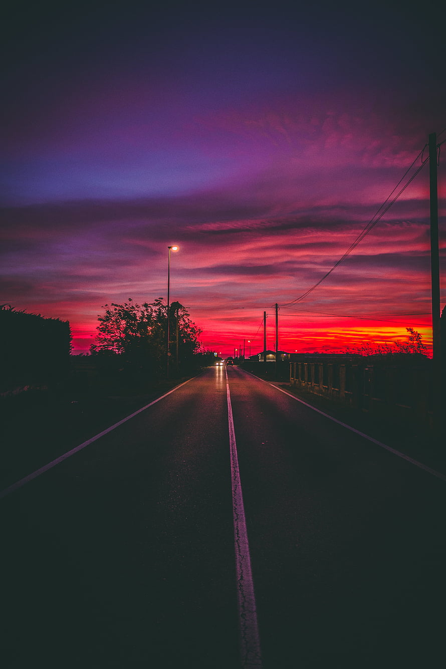 Vibrant Purple and Pink Sunset Over a Dark Asphalt Road at Dusk HD phone wallpaper